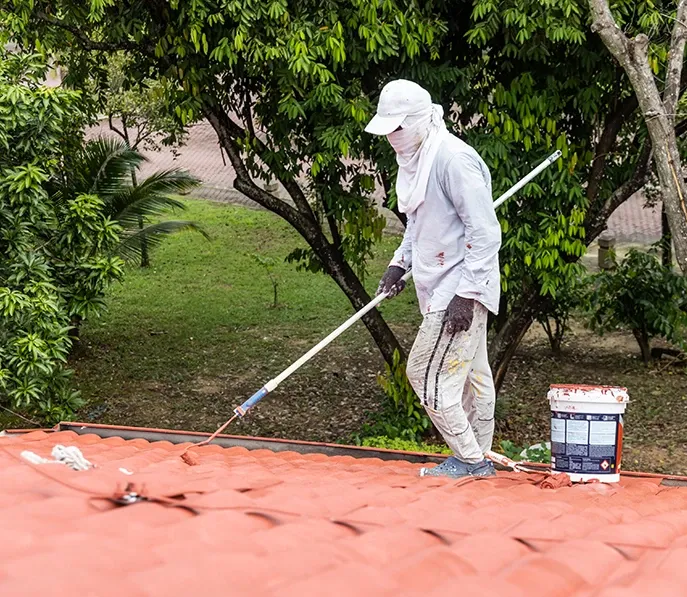 Roof being spray painted with protective coating